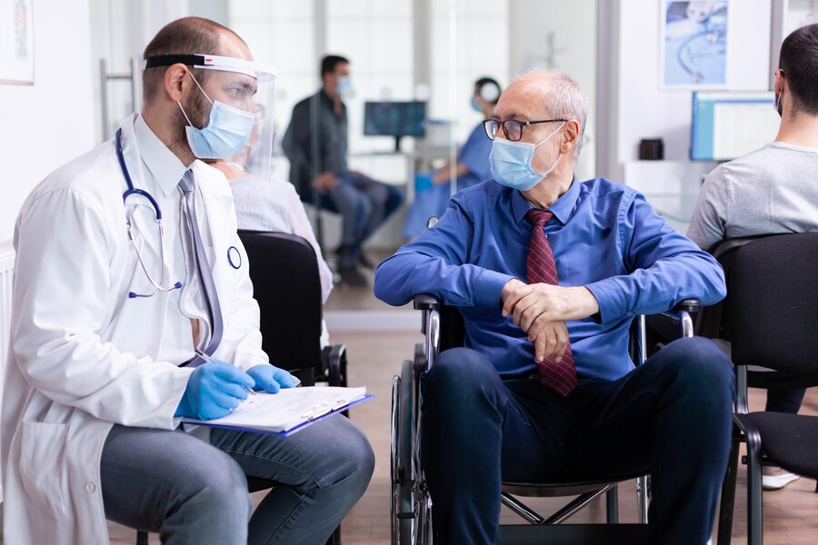 doctor-with-face-mask-stethoscope-consulting-disabled-senior-man-hospital-waiting-area_
