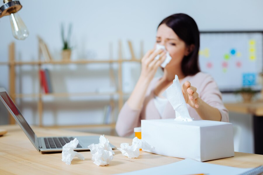 It is necessary. Upset office worker sitting on the background and wrinkling forehead while looking at carton box